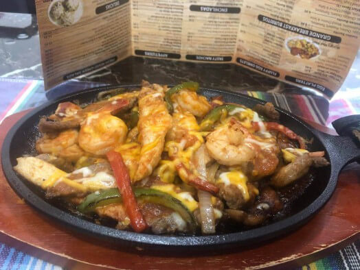 Sizzling Tex-Mex fajita plate with grilled chicken strips, sautéed bell peppers and onions.