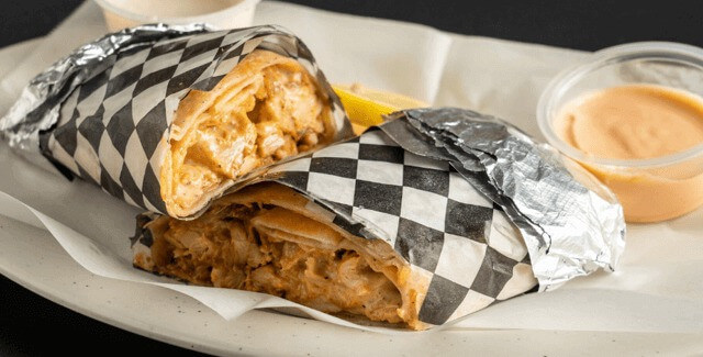 Chicken shawarma wrap with grilled chicken, vegetables, and sauces.