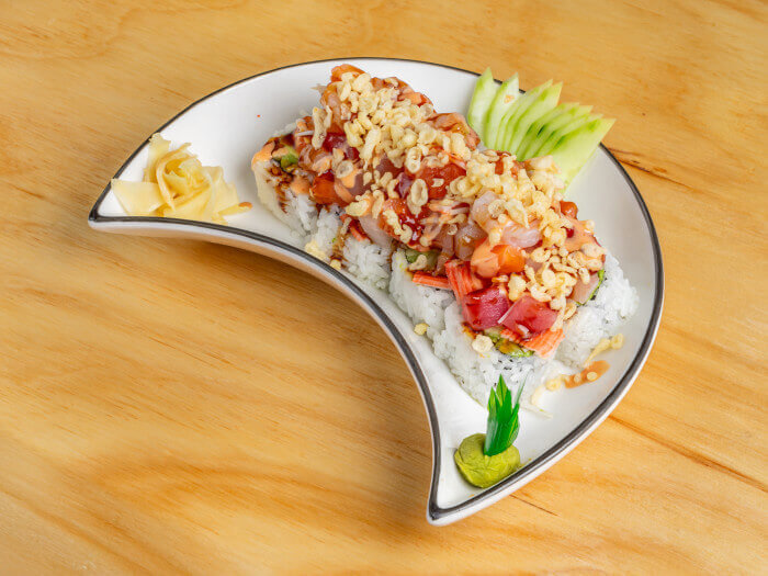 Hot Mama Roll with California base, topped with salmon, tuna, snapper, shrimp, and crab.