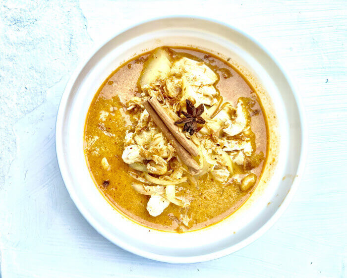 Creamy Vegan Massaman Curry with coconut milk, roasted peanuts, onions, and potatoes, served with jasmine rice.