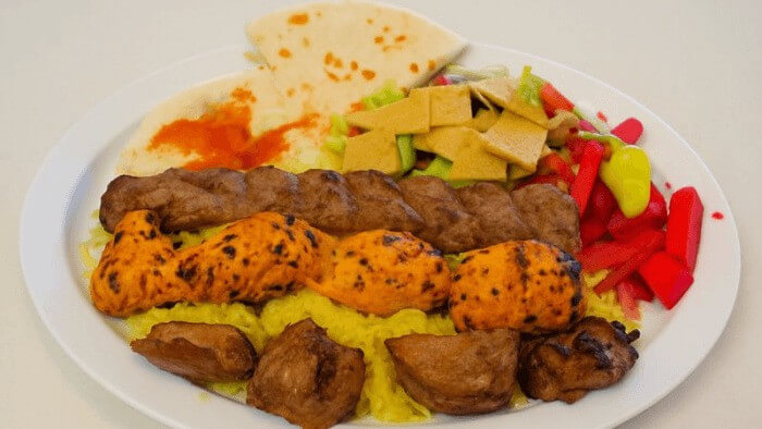 Three skewers: juicy kofta kebob, tender chicken, and beef filet, with basmati rice, side salad, creamy hummus and pita bread.