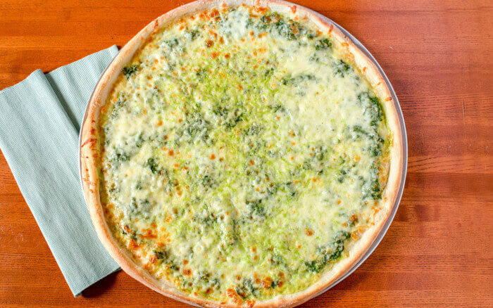 Spinach pizza slice with vibrant greens