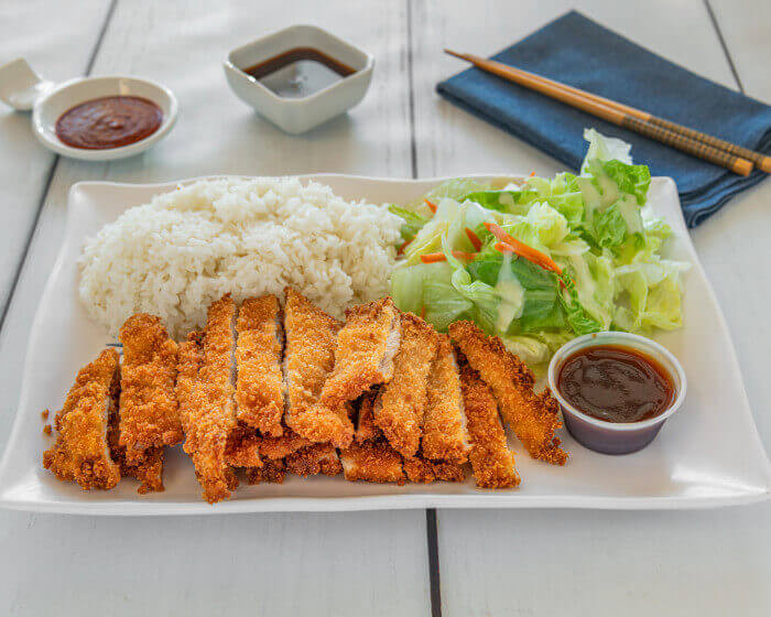Crispy panko-fried chicken cutlet with katsu sauce, rice, and salad