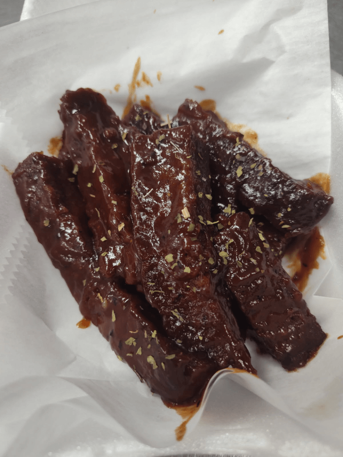 Tender, sauce-glazed vegan ribs plated with fresh greens.