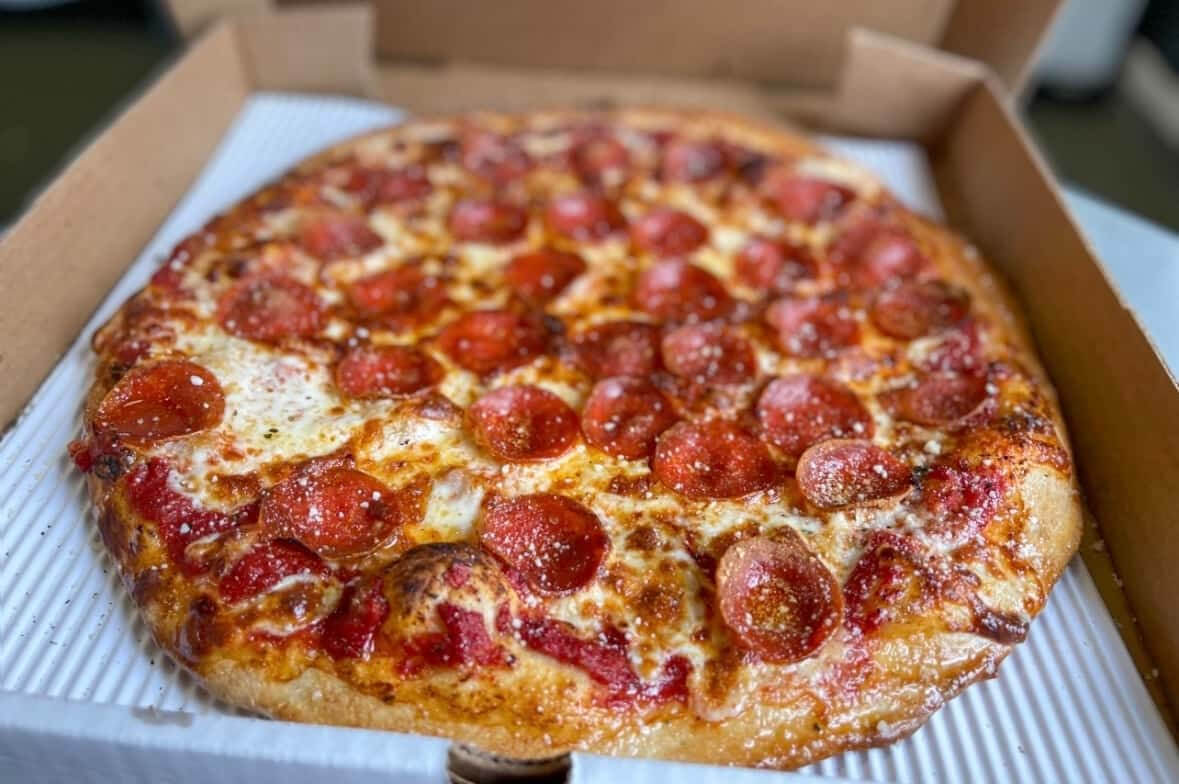 Table spread of pizza and sides served in Newport by Ghost Kitchen Pizza
